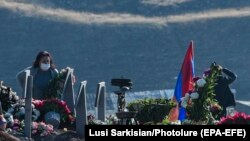 ARMENIA -- Relatives of soldiers killed during the war in Nagorno-Karabakh stand near graves at the Yerablur Military Cemetery in Yerevan, November 12, 2020