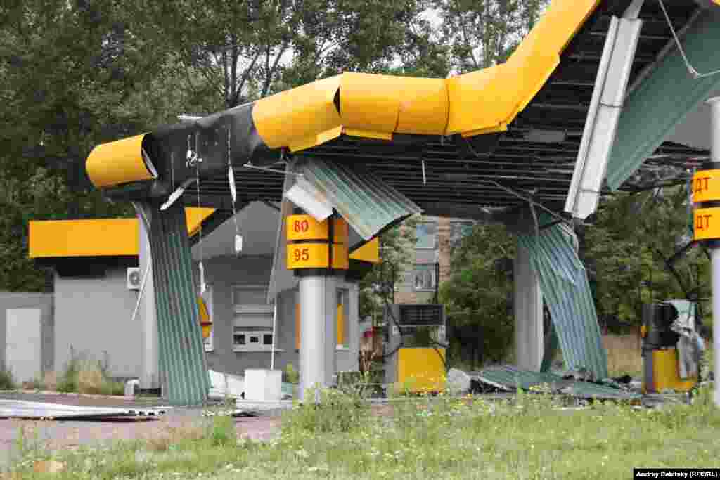 A damaged and deserted fueling station. 