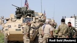 Kurdish fighters chat with members of U.S. forces in the town of Darbasiya, Syria, on April 29, 2017.