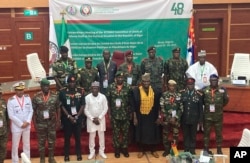 The defense chiefs from the Economic Community of West African States (ECOWAS), excluding Mali, Burkina Faso, Chad, Guinea and Niger, pose for a group photo during an extraordinary meeting in Abuja on August 4.