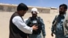 FILE: A wounded Afghan policeman stands guard at site of a suicide bomb attack in Zabul, May 2015.