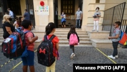 Disa nxënës duke hyrë në një shkollë në Romë, dhe duke respektuar masat kundër koronavirusit. Shtator 2020.