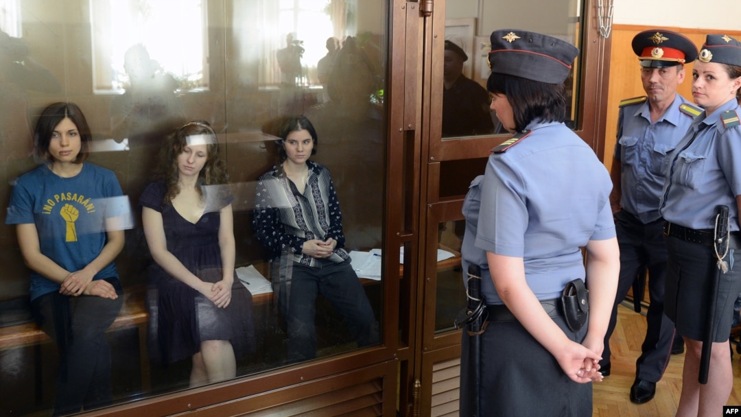 Nadezhda Tolokonnikova (left), Maria Alyokhina (center), and Yekaterina Samutsevich sit inside a glass enclosure during a court hearing in Moscow on August 8.
