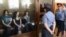 Nadezhda Tolokonnikova (left), Maria Alyokhina (center), and Yekaterina Samutsevich sit inside a glass enclosure during a court hearing in Moscow on August 8.