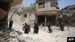 Iraqi women and children are evacuated from the Old City of Mosul on June 30.