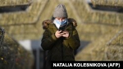 A woman uses her smartphone while walking in central Moscow. Several social media giants have been embroiled in a broad dispute with Russian authorities in recent months for not deleting material on their websites that has been banned in Russia. (file photo) 