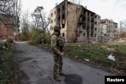 Український військовослужбовець стоїть біля житлових будинків в Авдіївці, 8 листопада 2023 року