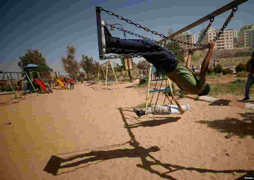 Palestinian protesters swing as they rest at a park during clashes with Israeli troops at a protest in support of Palestinian prisoners on hunger strike in Israeli jails, near the Jewish settlement of Beit El in the West Bank. (Reuters/Mohamad Torokman)