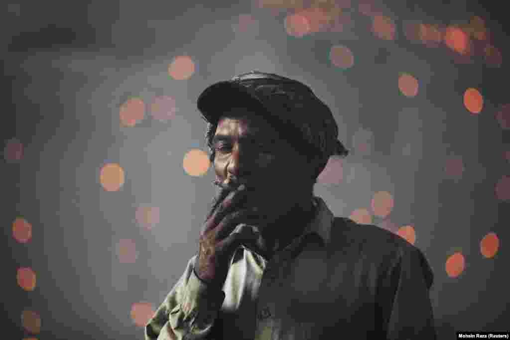 A Pakistani laborer smokes a cigarette as he takes a break from working in a foundry in Lahore. (Reuters/Mohsin Raza)