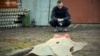 A man near the body of a woman who died during a Russian drone strike in Kyiv region, May 18 2025