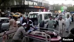 People carry an injured person to the hospital after a deadly attack at Kabul airport on August 26, 2021. 