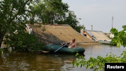 Чоловік на гумовому човні у затопленій Голій Пристані, червень 2023 року