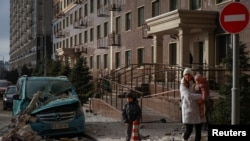 Жители на Одеса поминуваат покрај местото погодено со дрон, 19 јануари 2026 г.