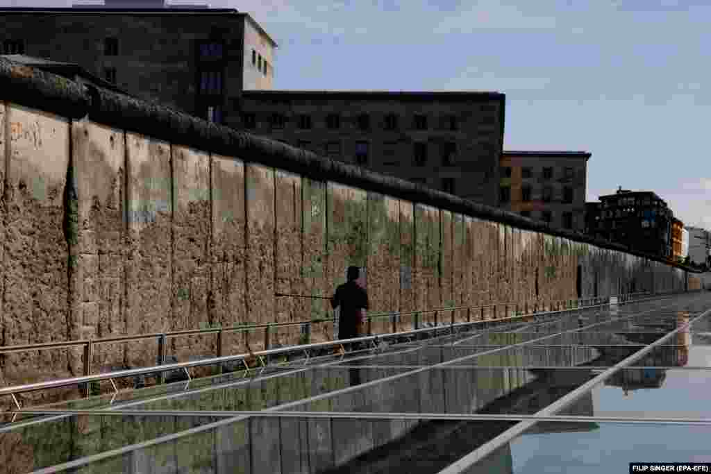 Një vizitor duke ecur pranë një pjese të mbetur të Murit të Berlinit, në vendin përkujtimor &quot;Topografia e terrorit&quot;, në Berlin. (12 gusht)