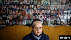 Hajra Ćatić ispred fotograija žrtava genocida u Srebrenici, 23. decembar 2014.