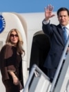 US Secretary of State Marco Rubio (right) waves next to his wife, Jeanette Dousdebes Rubio, as they board a plane to leave Samarkand on October 20. 