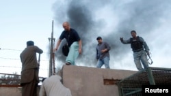 Afghans help a Red Cross member get away from the site of an attack in Jalalabad Province on May 29.