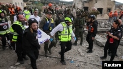 Emergency personnel carry a body at the site of an Iranian strike on the Israeli city of Beit Shemesh on March 1.