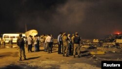 Security officials and airport staff visit the site damaged by Taliban attack on Jinnah International Airport in Karachi, June 9, 2014.