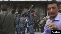 Police officers try to keep order in front of a branch of Kabul Bank today.