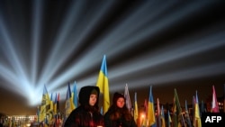 As people visit the Lychakiv Military Cemetery in Lviv on February 23, the eve of the third anniversary of Russia's invasion of Ukraine, a symbolic illumination called "Rays of Memory" is seen over the graves of Ukrainian soldiers who have died in the conflict. 