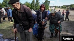 Residents from Vovchansk and nearby villages in the Kharkiv region wait for buses amid an evacuation to Kharkiv due to Russian shelling on May 10.
