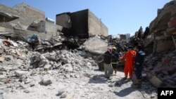 Цивили покрај оштетувања од воените судиири во ирачкиот град Мосул.  