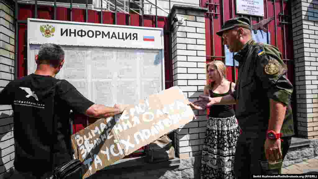 Плакат с основным своим призывом активисты хотели разместить на доске объявлений консульства России в Киеве – охранник не позволил.