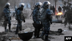 Riot police patrol the Kazakh town of Zhanaozen shortly after violence claimed the lives of at least 16 striking oil workers.