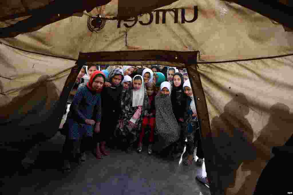 Afghan schoolgirls pose for a photograph at a makeshift camp due to the lack of proper school buildings in Herat. Although the Afghan government and foreign NGOs have taken initiatives to enroll schoolchildren across the country, millions of children of school age remain deprived of education and illiteracy is still widespread. (epa/Jalil Rezayee)