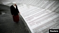 A Bosnian woman looks for the names of her dead relatives on a memorial plaque to the roughly 8,000 men and boys killed at Srebrenica.