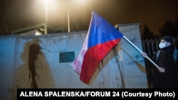 Një protestues mban një flamur kombëtar çek para Ambasadës Ruse në Pragë më 18 Prill.