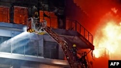 Stanovnik čeka na balkonu da bude spašen dok se vatrogasci bore sa ogromnim požarom koji bjesni kroz višespratni stambeni blok u Valensiji 22. februara 2024.