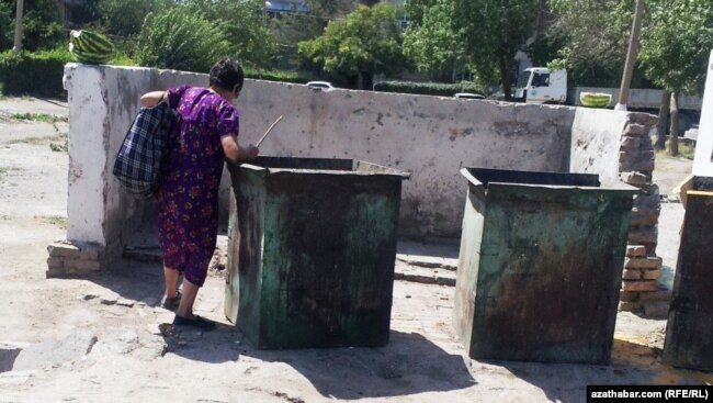 A woman looks in garbage cans for food in Ashgabat.