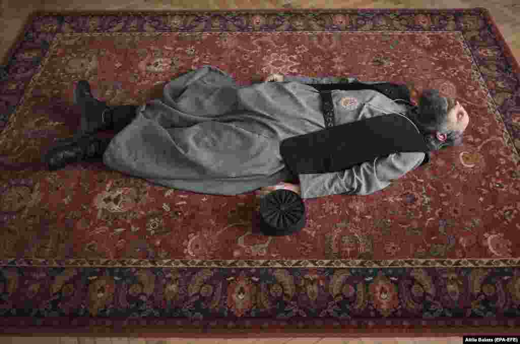 Greek Catholic Metropolitan Archbishop Fulop Kocsis stretches on the floor of his office in Debrecen, some 220 kilometers northeast of Budapest. (epa-EFE/Attila Balazs)
