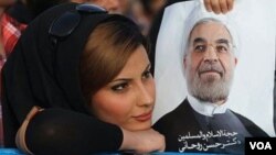 İranlı qadın Hassan Rohaninin plakatını tutub