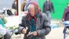 Femeie numărându-și banii din portofel în piața din orașul Nisporeni. 