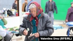 Femeie numărându-și banii din portofel în piața din orașul Nisporeni. 