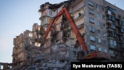 Workers dismantle a section of a building in Magnitogorsk hit by a blast on December 31, 2018.