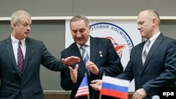 Russian cosmonauts Oleg Artemyev (R), Aleksandr Skvortsov (C) and NASA astronaut Steven Swanson shake hands after a press conference in Star City, outside Moscow, March 6, 2014