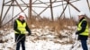 Latvian Energy Minister Kaspars Melnis (left) and Rolands Irklis, the CEO of Latvian electricity operator AST, pose with a severed cable after technicians worked on the disconnection of a major power line between Latvia and Russia on February 8. 