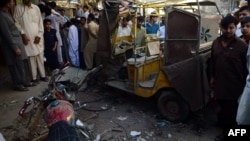 Locals gather at the site of an overnight bomb blast in Karachi on March 15.