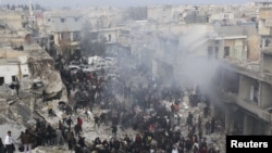 People gather at a site hit by missiles fired by a government air force fighter jet in Azaz, north of Aleppo, on January 13.