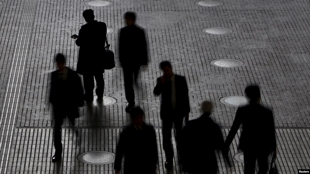 eople walk at an office building at a business district