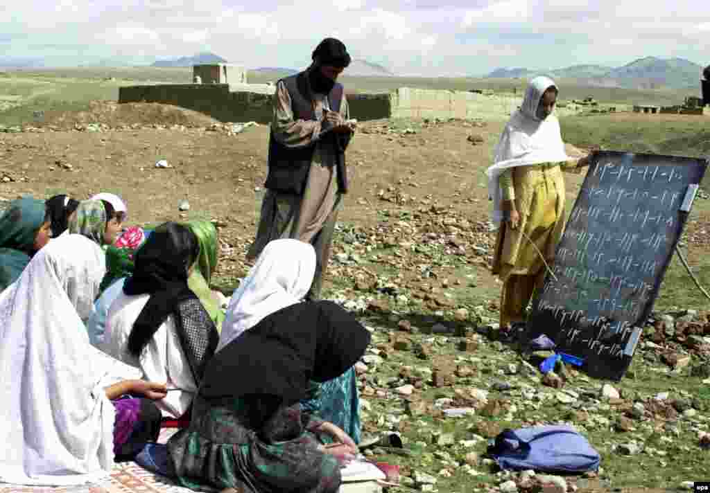 Girls study in an open-air class while waiting for a new school to be built in the background (epa) - In 2001, the Afghan education system barely existed. There has been some improvement, but Afghanistan remains largely illiterate -- more than three in five adults cannot read or write. Moreover, one of the early achievements – the return of at least a few girls (6 percent or so) to the schoolroom – is now in reverse in parts of the country, with the Taliban targeting schools. 