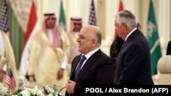 Iraqi Prime Minister Haider al-Abadi (C) smiles after meeting with US Secretary of State Rex Tillerson (R) before a meeting of the Saudi-Iraqi Bilateral Coordination Council in the Saudi capital Riyadh on October 22, 2017.