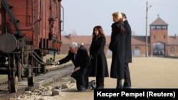 U.S. Vice President Mike Pence (kneeling), with wife Karen, and Polish President Andrzej Duda visits the Nazis' Auschwitz extermination camp on February 15.