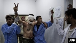 A Libyan rebel wounded during battle for control of the oil town of Brega flashes a victory sign as he is taken to the emergency room at the general hospital in Ajdabiya on July 17.