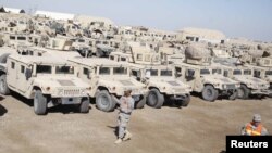 U.S. soldiers check military vehicles to be shipped as troops prepare to pull out of a military base in Nasiriyah last month.