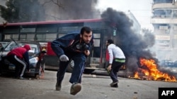 Supporters of Egypt's deposed President Muhammad Morsi run for cover from tear gas fired by riot police during clashes in the northeastern part of Cairo's Nasr City district on January 3.